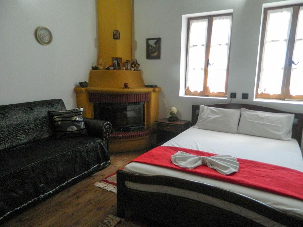 ein Schlafzimmer mit einem Bett und einem Sofa in der Unterkunft Guesthouse Klearchos in Palaios Panteleimonas
