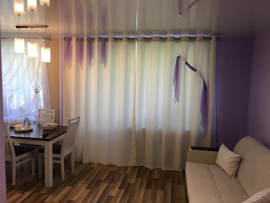 ソルタヴァラにあるОднокомнатная квартираのリビングルーム(テーブル、白いカーテン付)