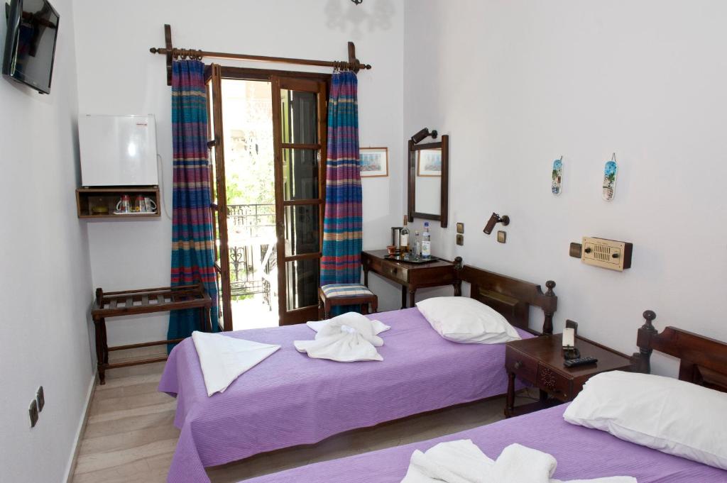 a bedroom with two beds and a window at Pegasus Hotel in Pythagoreio