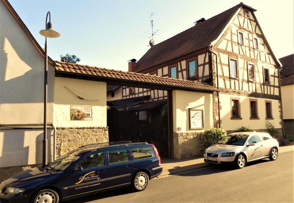 two cars parked in front of a building at Ferienwohnung BogenTenne in Eußenheim