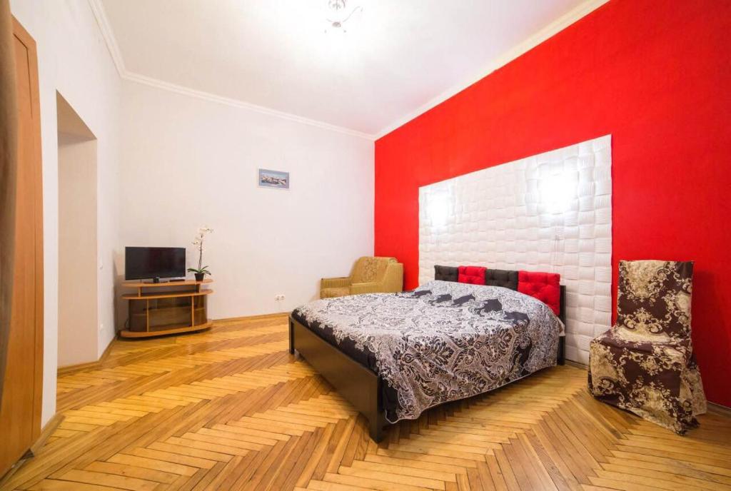 リヴィウにあるApartment on Krakivska 26の赤い壁のベッドルーム1室(ベッド1台付)