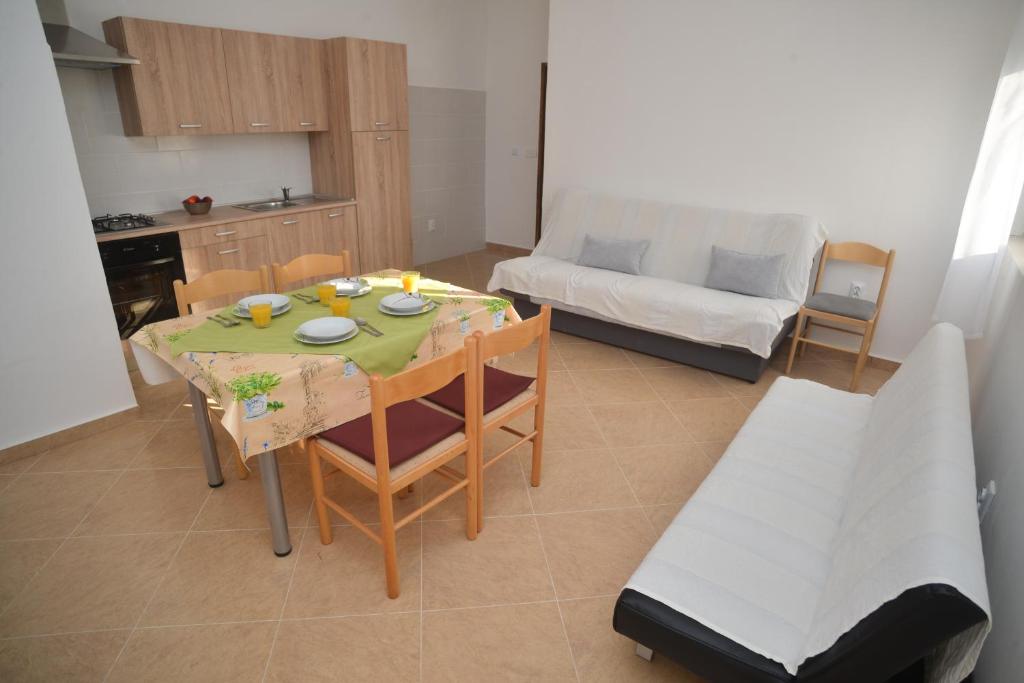 cocina y sala de estar con mesa y sofá en Apartments Lavanda, en Turanj