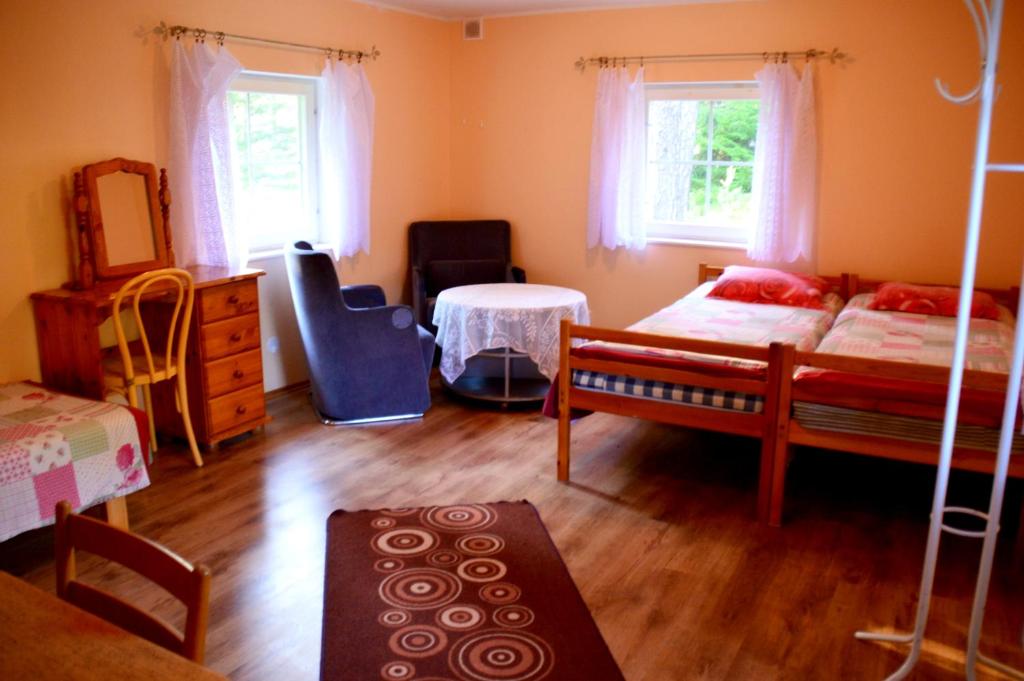a bedroom with two beds and a table at Roosi Camping Houses in Rannaküla