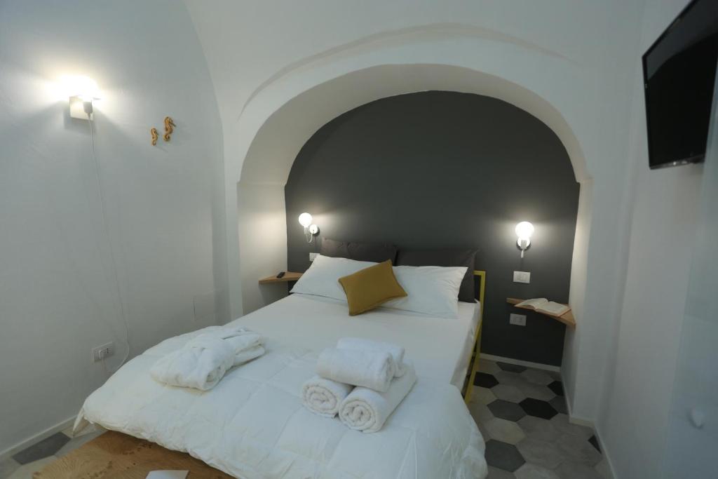 a bedroom with a white bed with towels on it at FONTEblu B&B in Polignano a Mare