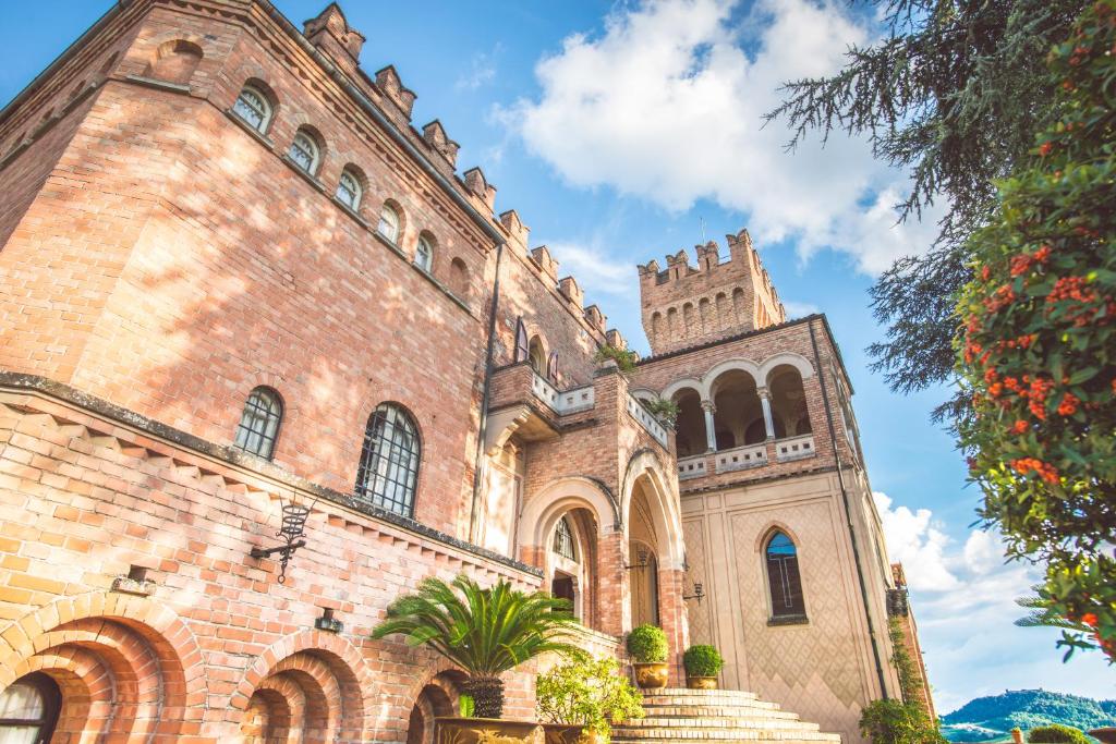un gran edificio de ladrillo con una torre de reloj en Castello Di Mornico Losana, en Mornico Losana
