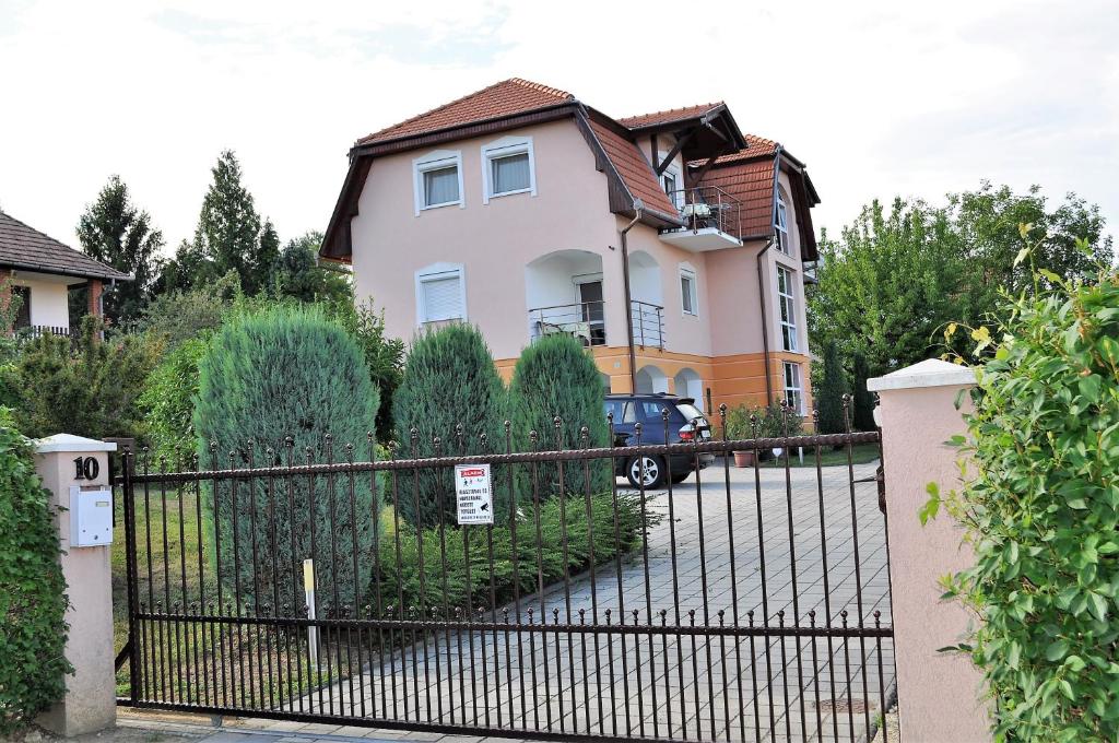 una casa con una recinzione nera davanti di Katalin Apartmanház a Zalakaros