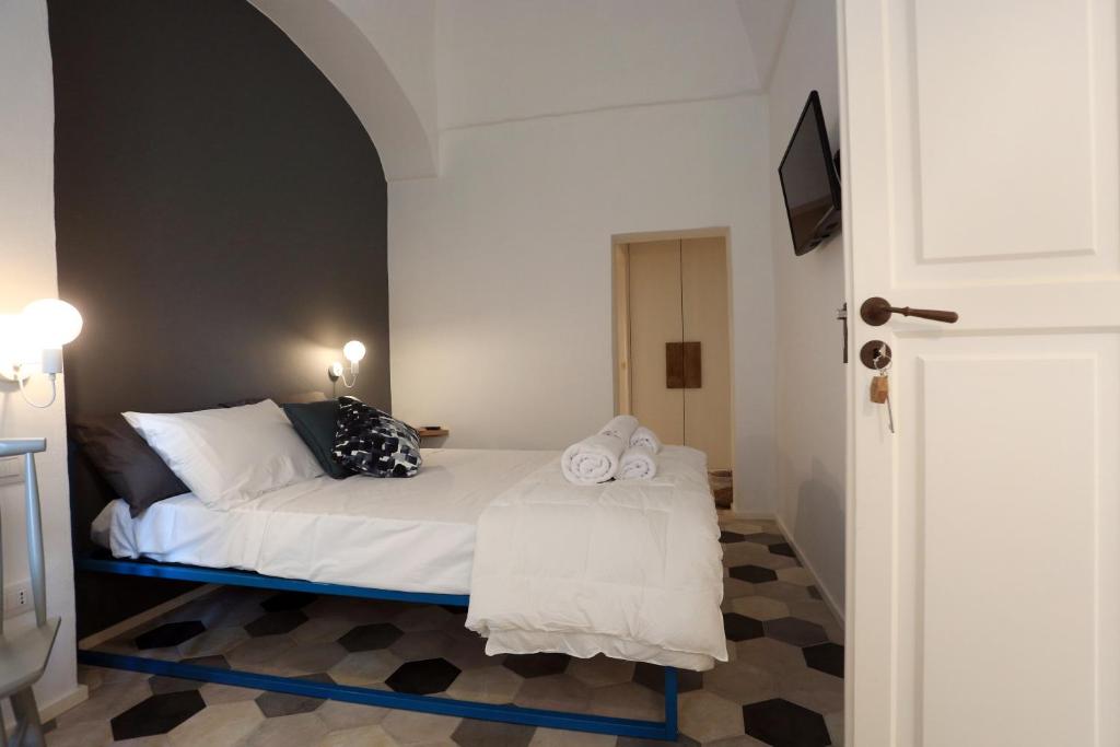 a bedroom with a bed with white sheets and pillows at FONTEblu B&B in Polignano a Mare