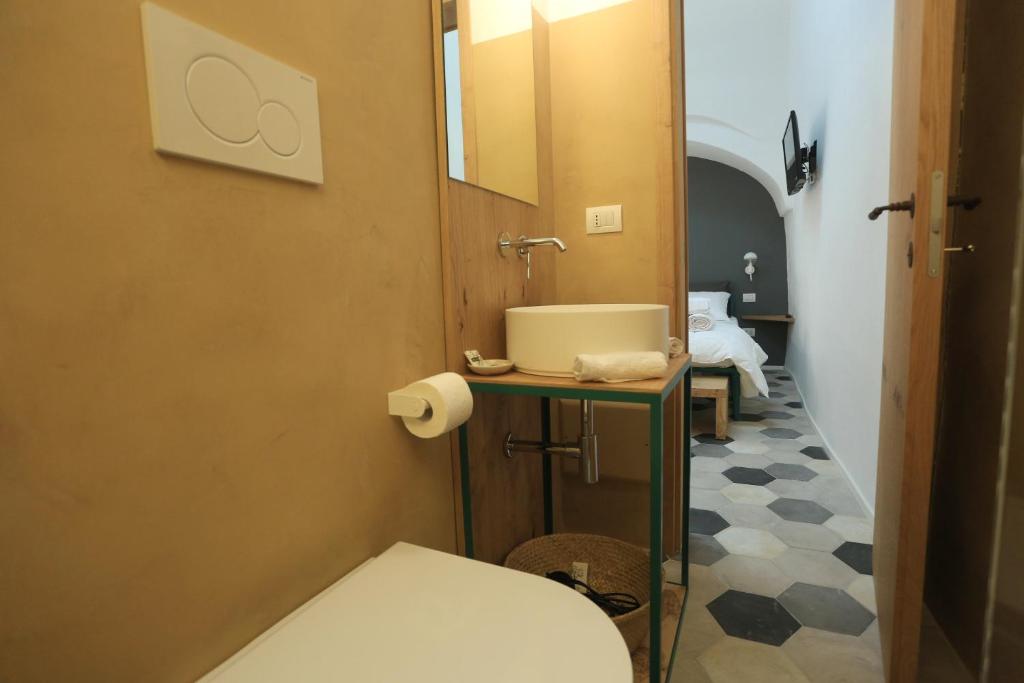 a bathroom with a toilet and a mirror at FONTEblu B&B in Polignano a Mare