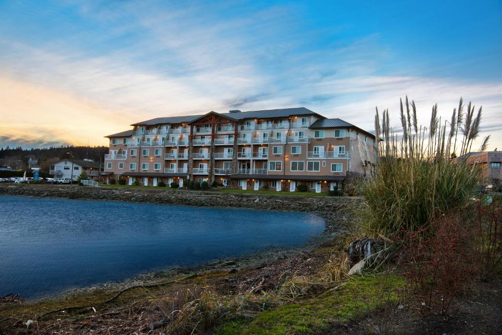 a large apartment building next to a body of water at Oxford Suites Silverdale in Silverdale