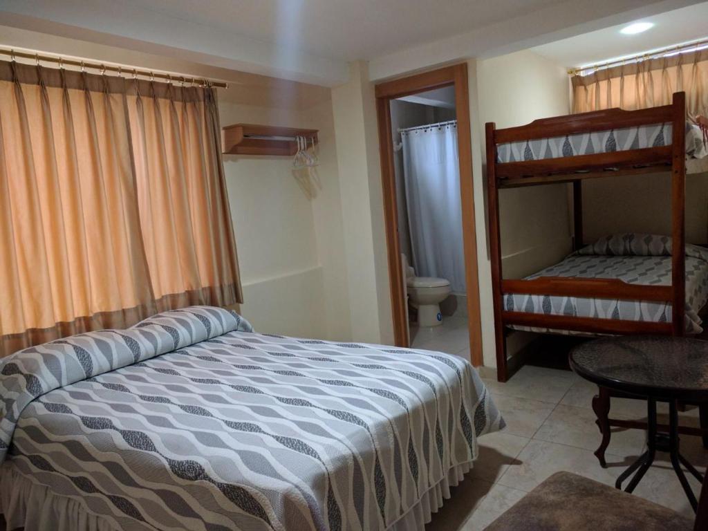 1 dormitorio con 1 cama y 1 litera en Hotel Mileto, en Salinas