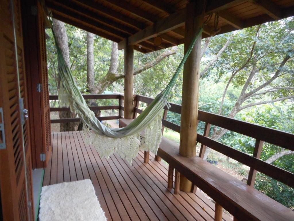 a hammock on the porch of a cabin at Chalé Siriú - entre o rio e o mar in Siriú