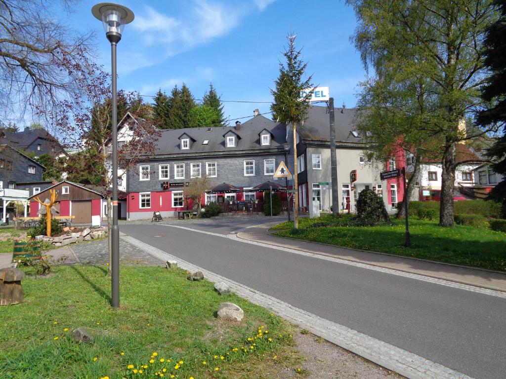 a street in a town with houses and a street light at Pension & Gasthof "Am Park" UG in Stützerbach