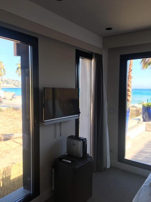 a room with a tv and two large windows at H Boutique Peña Parda in La Herradura