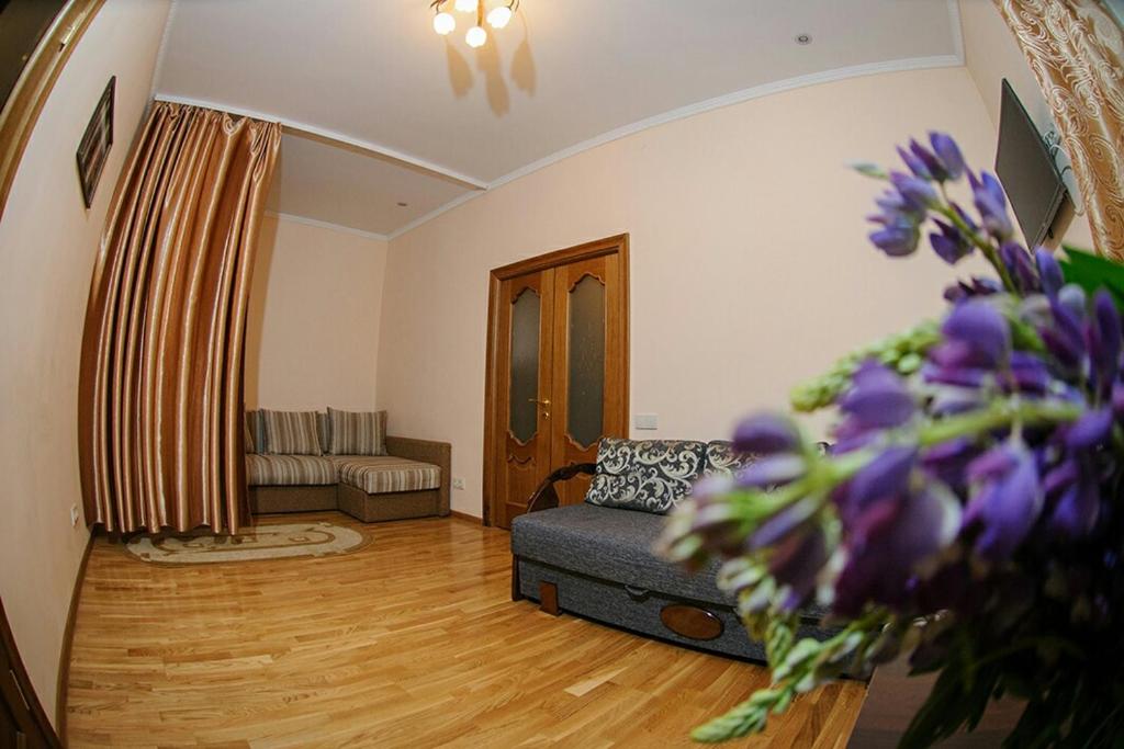 リヴィウにあるApartment on brativ Rohatyntsiv 3のリビングルーム(ソファ付)、紫の花が飾られたリビングルーム