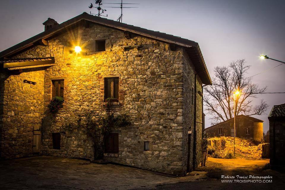 ein altes Steingebäude mit zwei Lichtern oben in der Unterkunft Agriturismo Corte del Gallo in Rivergaro