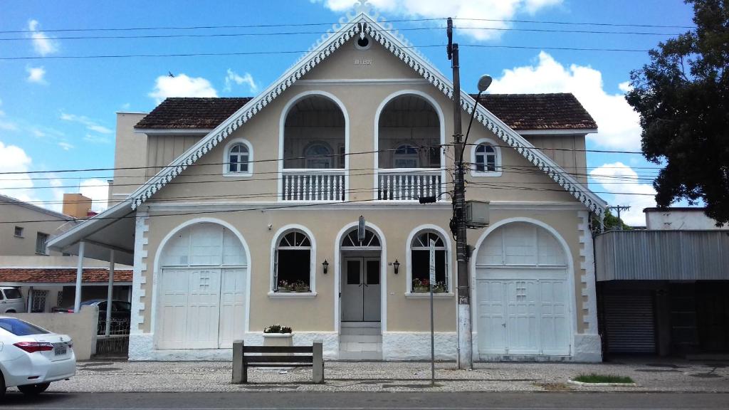 a white house with two garage doors on a street at Hotel Scholze in Canoinhas