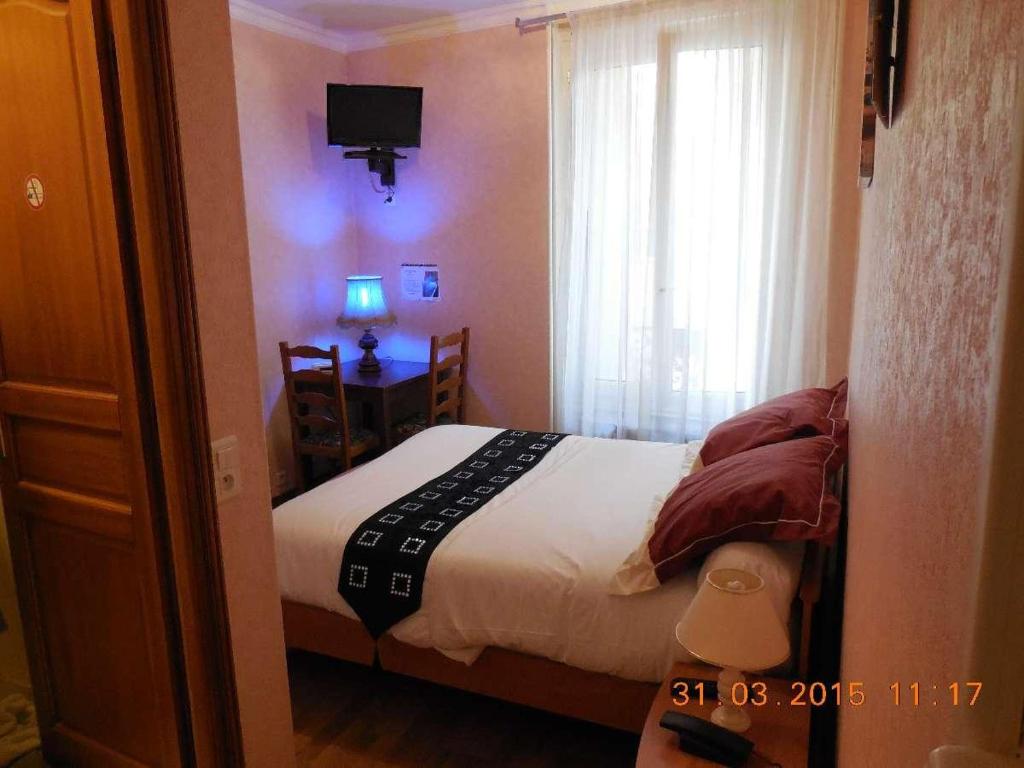 - une petite chambre avec un lit et une fenêtre dans l'établissement Hôtel le Petit Château proche parc des expositions porte de versailles, à Malakoff