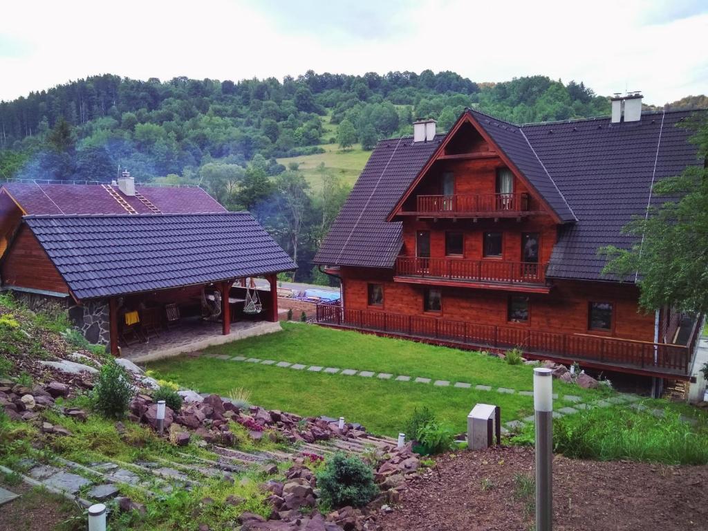 une grande maison en bois avec une cour en face de celle-ci dans l'établissement Bystrá Apartments Deer and Wolf, à Bystrá