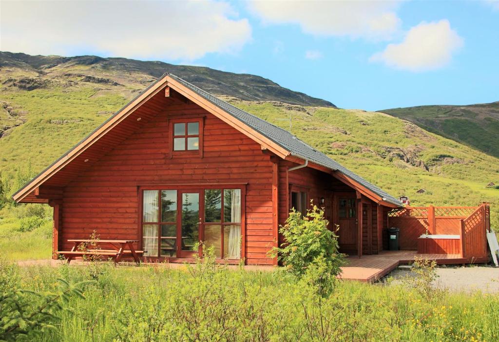 レイクホルトにあるGeysir - Modern Log Cabinの草原を背景にしたログキャビン