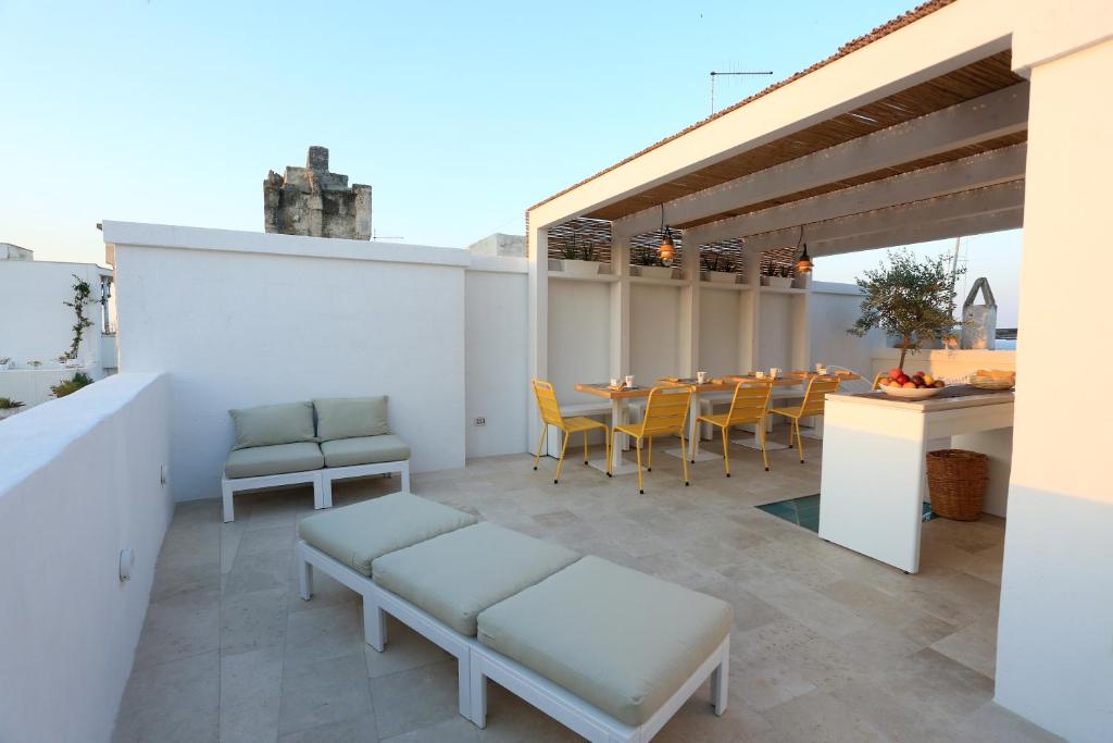 a patio with a table and chairs on a roof at FONTEblu B&B in Polignano a Mare