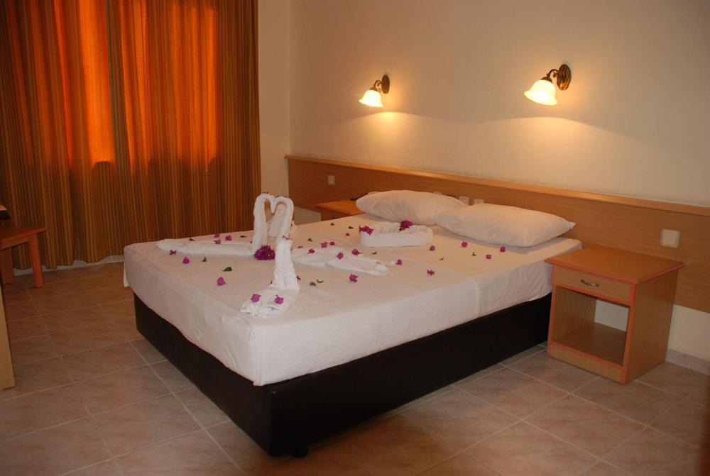 a bedroom with a bed with shoes on it at Grand Horizon Apart Hotel in Alanya