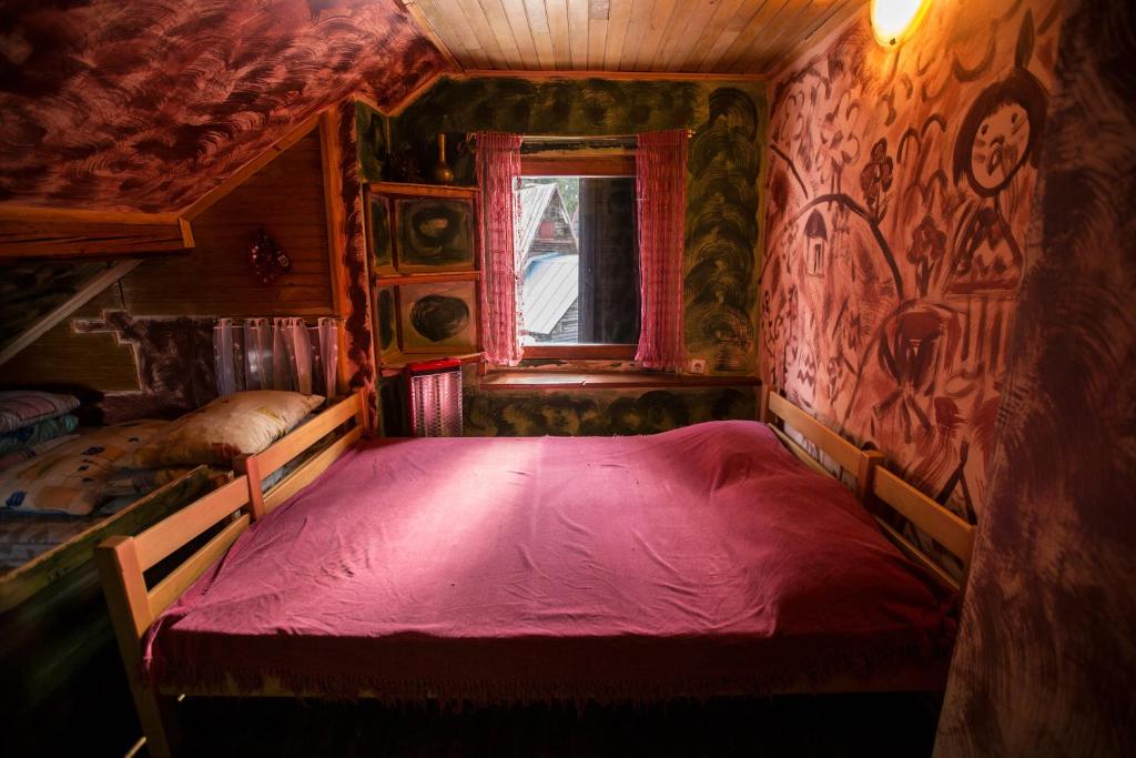 sypialnia z czerwonym łóżkiem w pokoju z oknem w obiekcie Chalet Baluma Maluba w mieście Jahorina