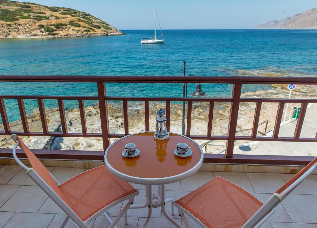 una mesa y sillas en un balcón con vistas al océano en Koilon Apartments, en Mókhlos