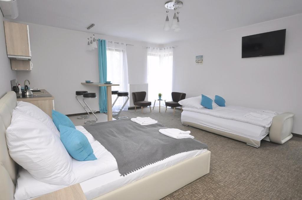 ヤストシェンビャ・グラにあるApartamenty Patriaのベッドルーム1室(ベッド2台付)、リビングルームが備わります。