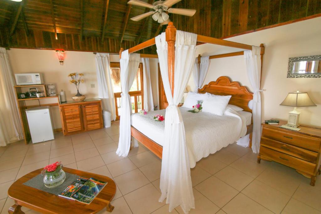 Schlafzimmer mit einem großen Bett und einem Deckenventilator in der Unterkunft Catcha Falling Star in Negril