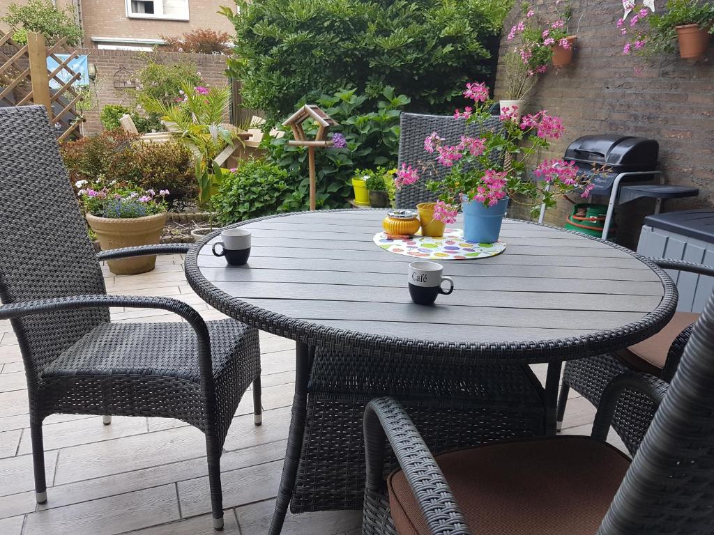 een houten tafel met twee kopjes op een patio bij B&B Acacia in Goirle