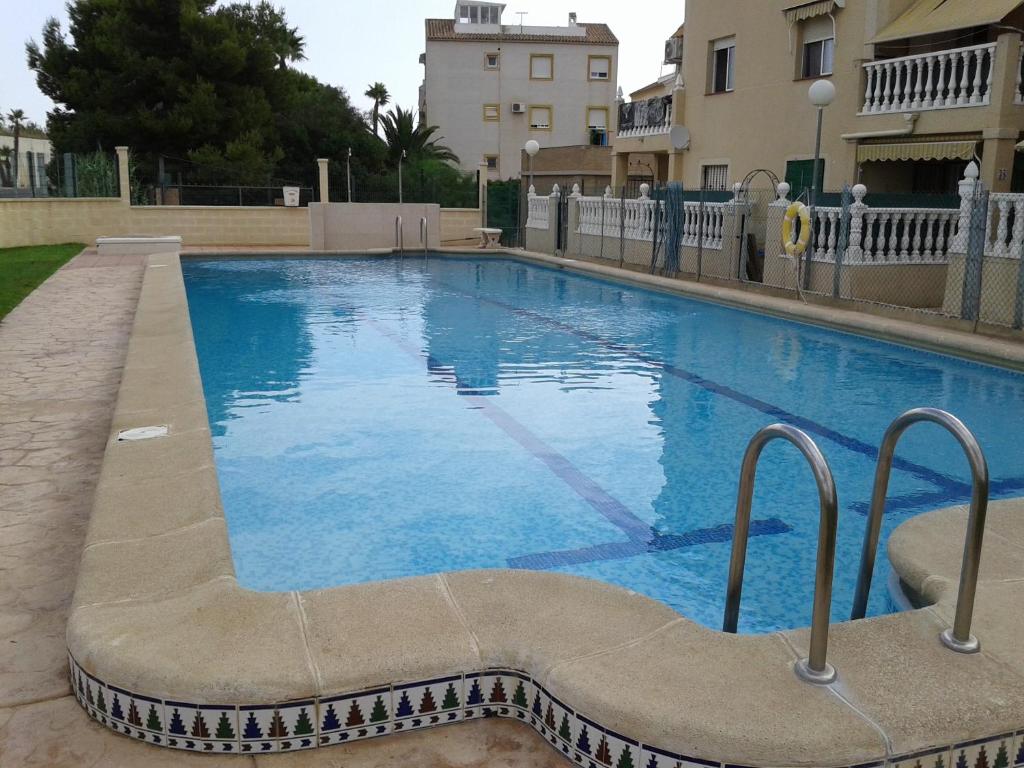 a large blue swimming pool next to a building at Apartement à La Mata in Torrevieja