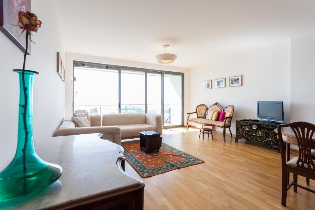 ein Wohnzimmer mit einem Sofa und einem Tisch in der Unterkunft FLH Expo Flat with View in Lissabon