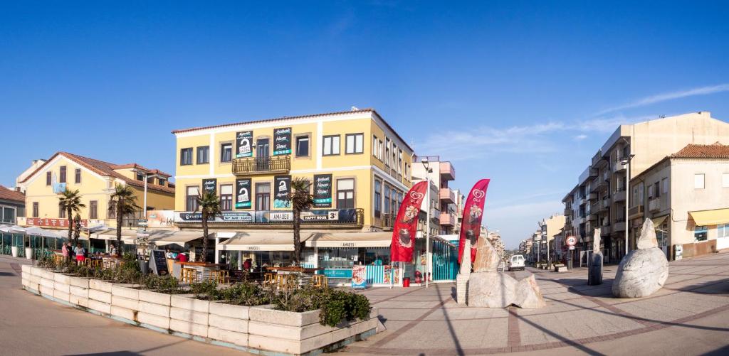 una calle en una ciudad con edificios y palmeras en Furabeach Alojamentos, en Furadouro