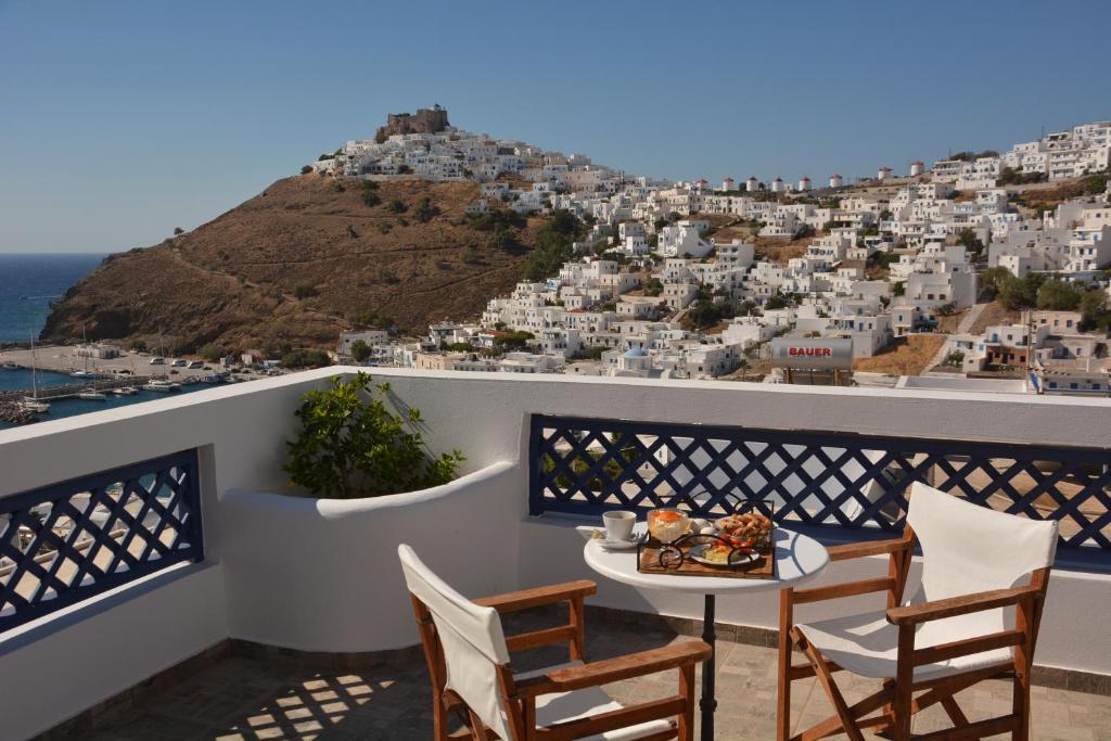 a table and chairs on a balcony with a view at Belvedere Studios in Astypalaia Town