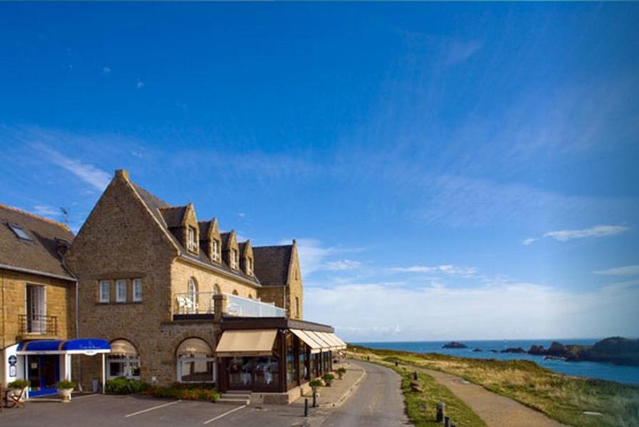 カンカルにあるHôtel de la Pointe du Grouinの海を背景にした大きな建物