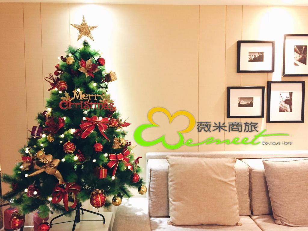 a christmas tree in a living room with a couch at Wemeet Hotel Taipei in Taipei