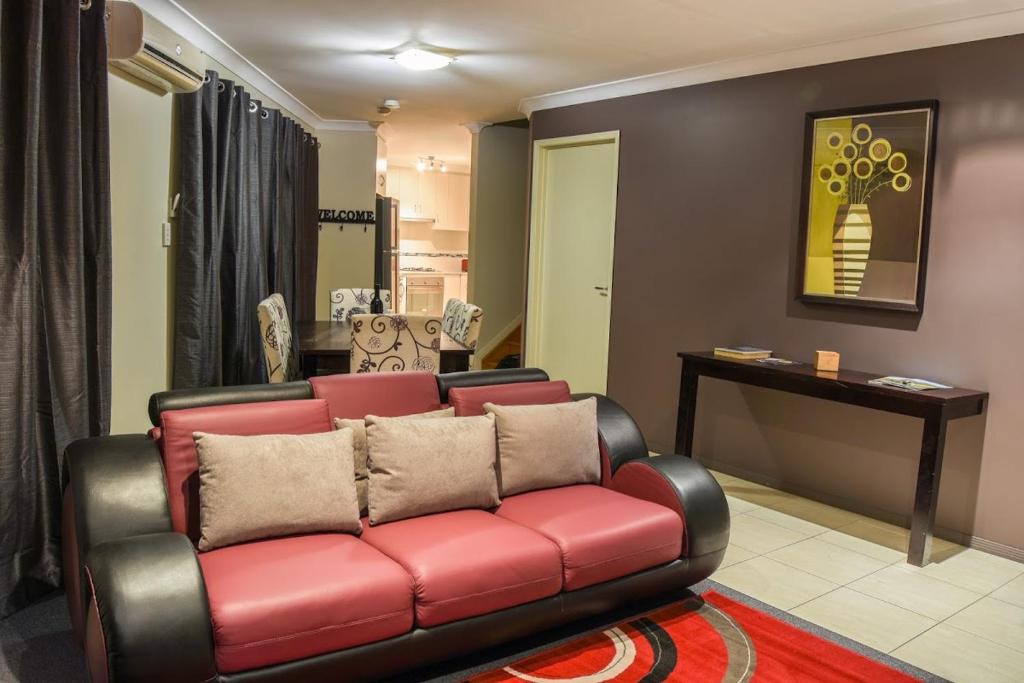 a living room with a red couch and a table at Atricom in Stanthorpe