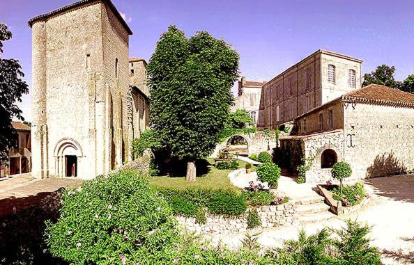 a large stone building with a tree in front of it at L'Atelier d'Aubiac in Aubiac