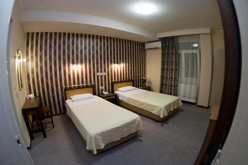 Postel nebo postele na pokoji v ubytování Olympos Hotel