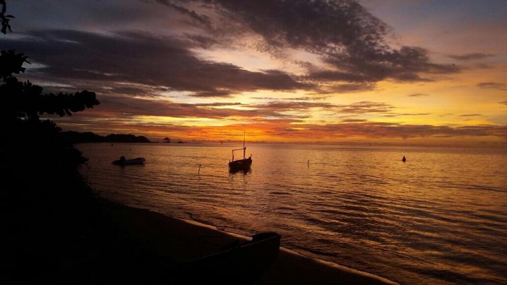 un tramonto con due barche in acqua di Villa Isabella Putri B&B a Jepara