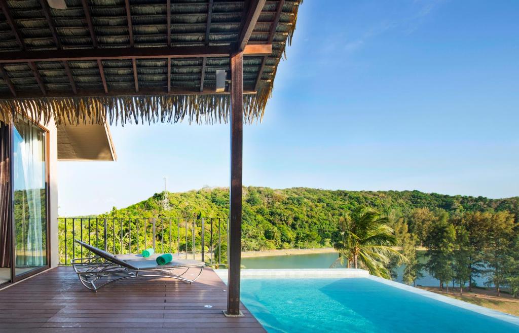 a resort with a pool and a view of the ocean at Sunsuri Phuket - SHA Plus in Nai Harn Beach