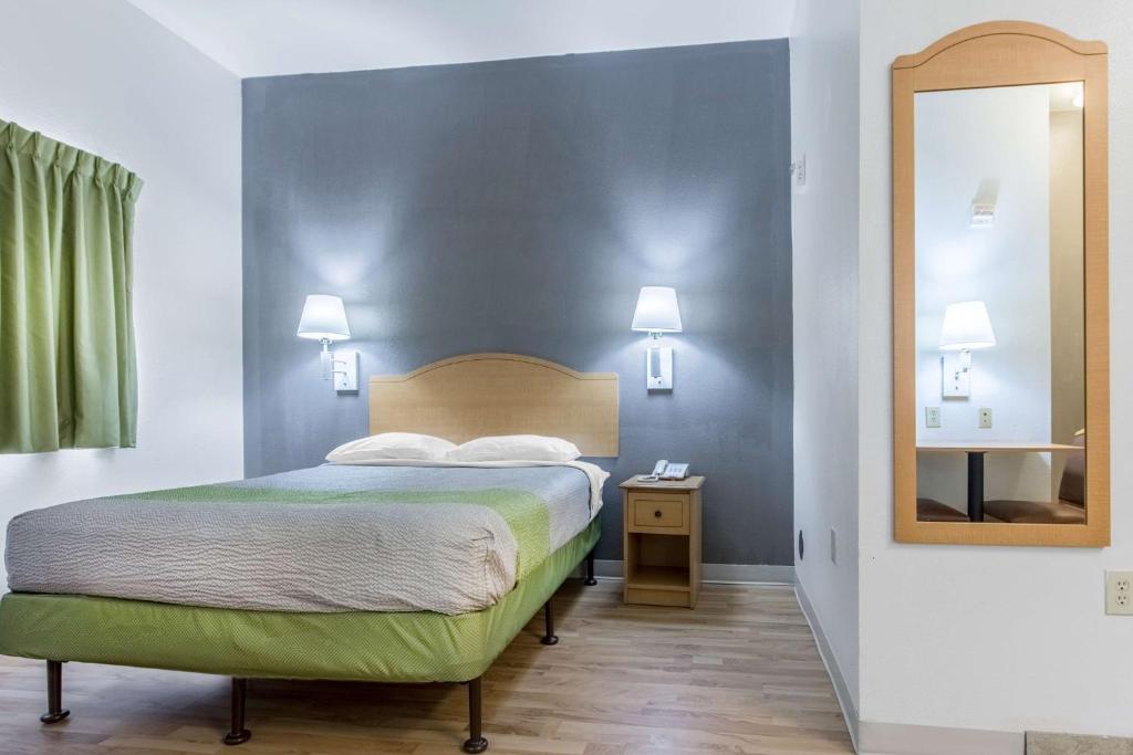a hotel room with a bed and a mirror at Studio 6-Lafayette, LA - Broussard in Lafayette
