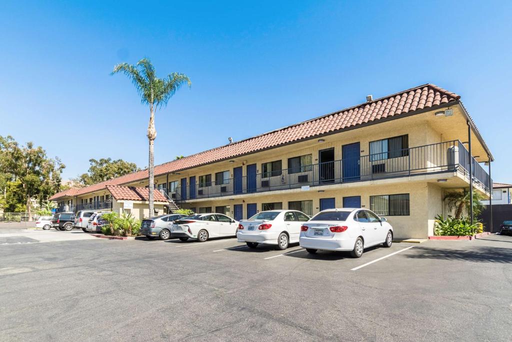 a parking lot in front of a hotel with parked cars at Motel 6 Riverside, CA - UCR East in Riverside