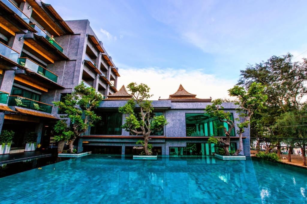 a swimming pool in front of a building at I Calm Resort Cha Am in Cha Am