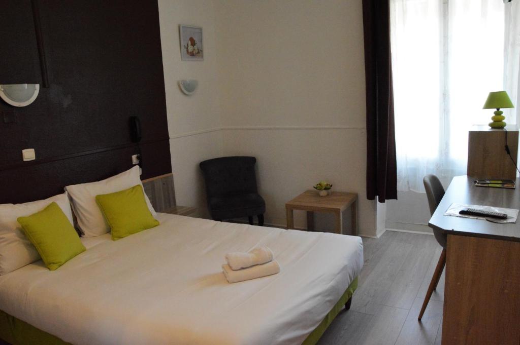 a bedroom with a bed with two towels on it at Hôtel de la Colombière in Chalon-sur-Saône