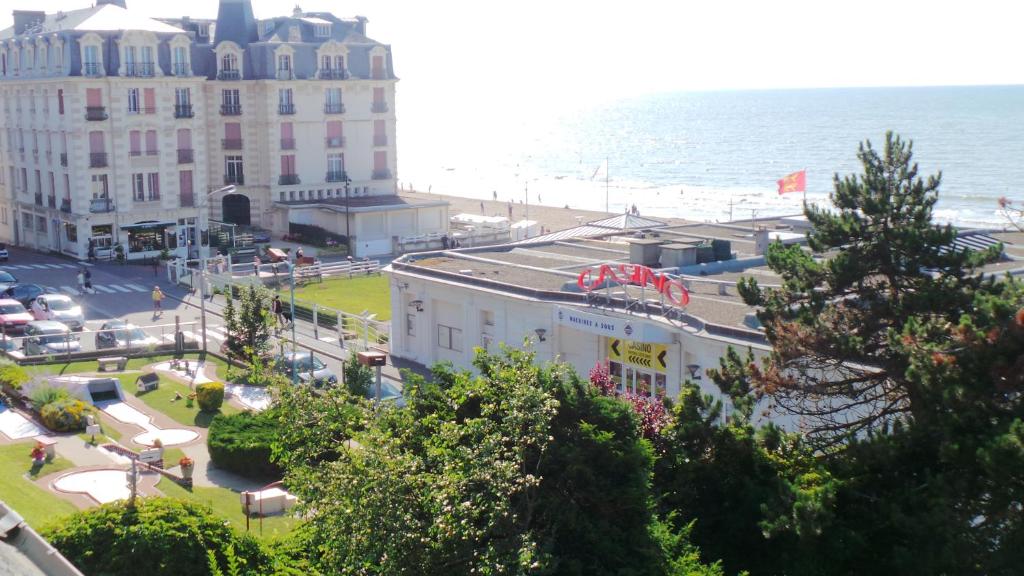 vista su una spiaggia e su un edificio e sull'oceano di Residence le Crisenoy a Houlgate