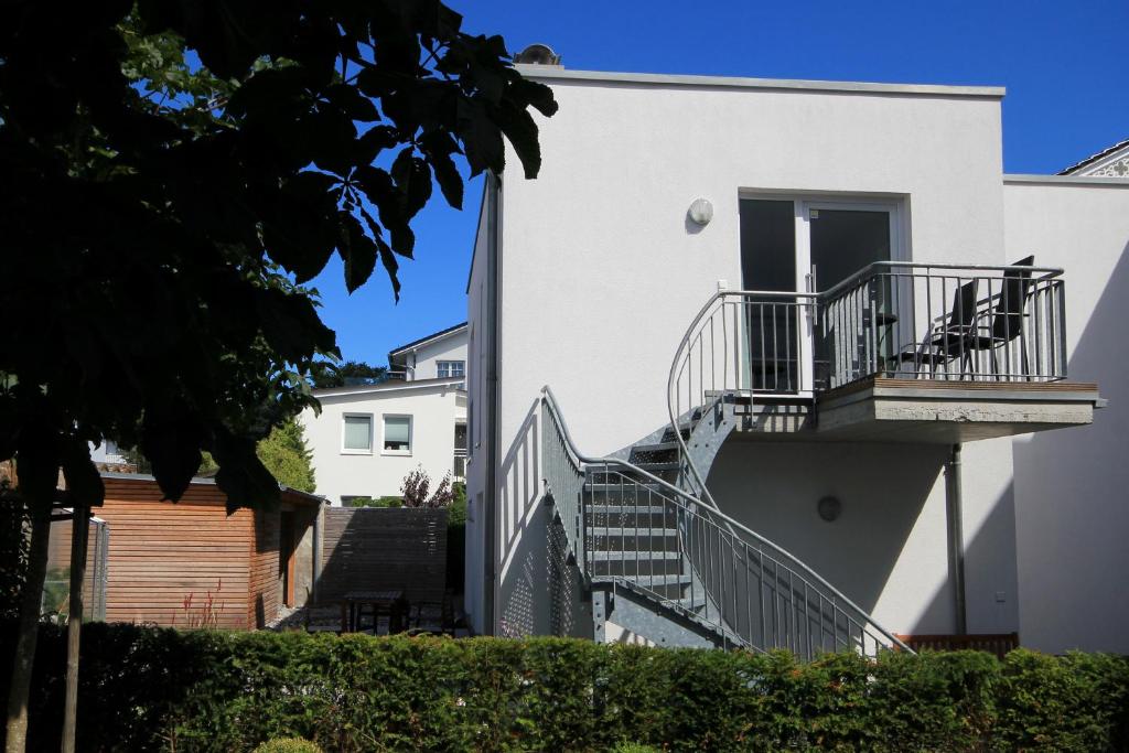 a white house with stairs leading up to a door at Haus Putbus by Rujana in Binz