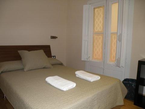 a bedroom with a bed with two towels on it at Center Gran Via in Barcelona