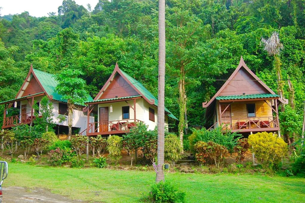 three cottages in the middle of a forest at TP Hut Bungalows in Ko Chang