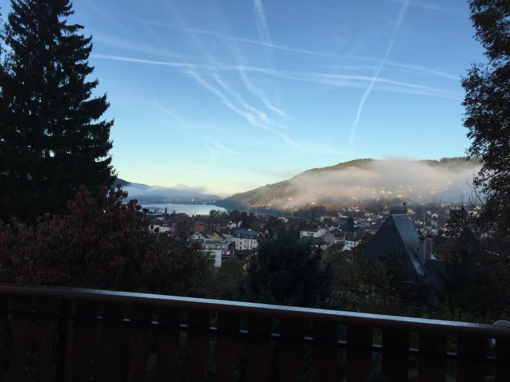 a view of a city with clouds in the sky at Chalet la roche du rain in Gérardmer